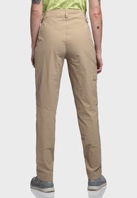 Beige Cargo-Hosen mit geradem Schnitt, ausgestattet mit einer Seitentasche, aus leichtem Stoff und kombiniert mit grauem Schuhwerk.
