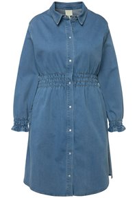Abito camicia in denim di colore azzurro chiaro, con una chiusura anteriore a bottoni, vita arricciata, maniche lunghe con polsini arricciati e un orlo appena sopra il ginocchio.
