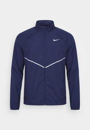 Marineblaue Jacke mit durchgehendem Reißverschluss, weißem Nike-Swoosh auf der linken Brust und weißen schrägen reflektierenden Streifen vorne.