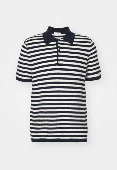 Kortärmad polo i marinblå och vit randig mönster, med en enfärgad marinblå krage och treknappslåst, tillverkad av mjukt texturerat tyg.