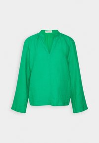 Blusa de lino verde con mangas largas, escote en V y detalles fruncidos en los hombros. Textura suave, ajuste relajado y líneas limpias.