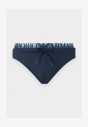 Marineblaue Herren-Badehose mit Kordelzug vorne und elastischem Bund mit "EMPORIO ARMANI" Schriftzug und Logo in Marineblau auf hellblauem Hintergrund.