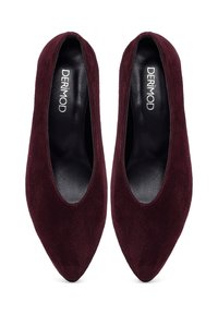 Chaussures en daim bordeaux à bout pointu avec un intérieur noir lisse, présentant un design minimaliste et sans fixations visibles.