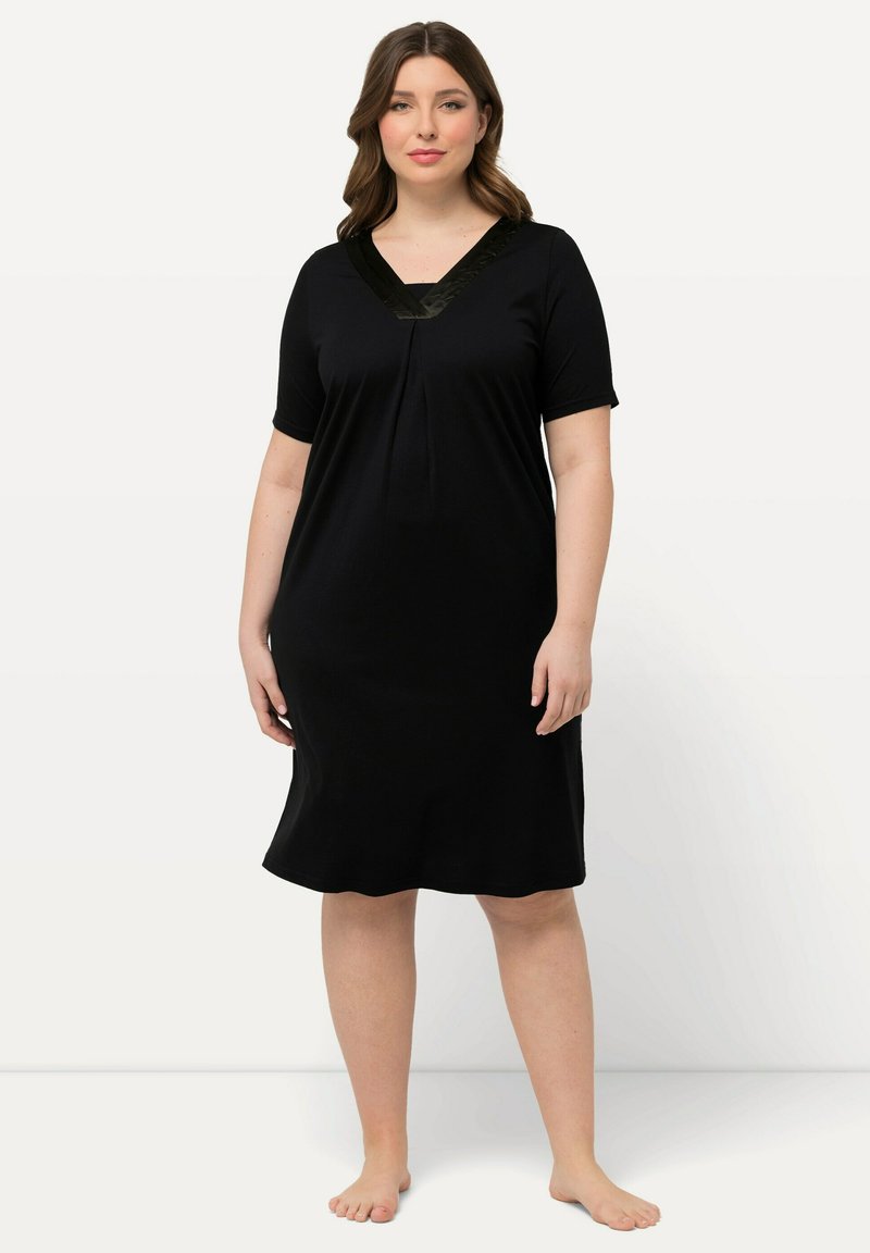Vestido de dormir corto negro de manga corta con escote en V y detalles de encaje. Fabricado con una tela suave, presenta un corte holgado y un diseño a la altura de la rodilla.