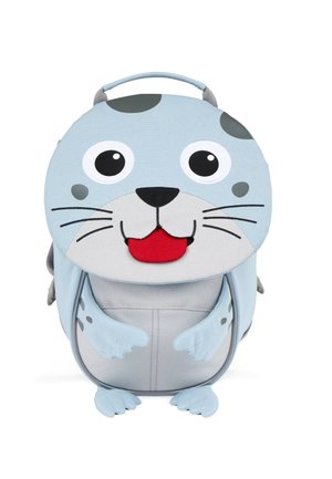 Round blue backpack shaped like a seal, featuring large eyes, gray accents, and a red tongue. Textured fabric with flipper-like straps.