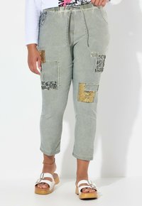 Pantalons cropped vert clair avec des patches en tissu mélangé, y compris un imprimé léopard et des accents dorés, coupe étroite et taille élastique.