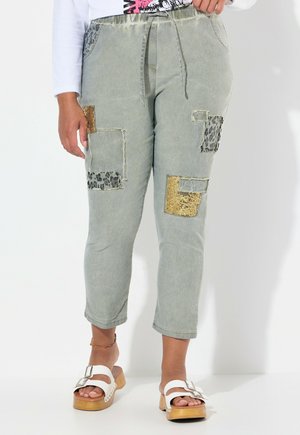 Light green cropped pants with mixed fabric patches, including leopard print and gold accents, narrow leg fit, and elastic waist.