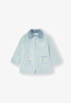 Chaqueta de vellón azul claro con cuello. Presenta un gráfico bordado de un cohete y un bolsillo con un ribete azul. Textura suave, cierre frontal con cremallera.