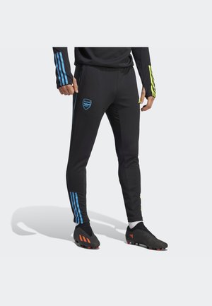 Black athletic pants with blue and yellow side stripes, featuring an Arsenal logo on the front and a tapered shape.