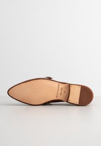 Semelle de chaussure en cuir marron avec bout pointu, présentant une surface lisse et un logo embossé. Taille 37 indiquée sur la semelle intérieure.