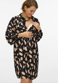 Czarna sukienka z beżowym abstrakcyjnym wzorem, długimi rękawami, zapinana na guziki z przodu, luźnym krojem i miękką fakturą. Charakterystyczna dzięki dostępowi umożliwiającemu karmienie piersią.