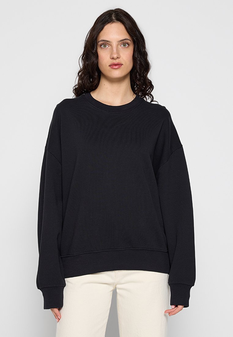 Schwarzer, übergroßer Sweatshirt mit Rippkragen und langen Ärmeln. Aus weichem Stoff gefertigt, bietet es eine lockere Passform und eine subtile Textur.