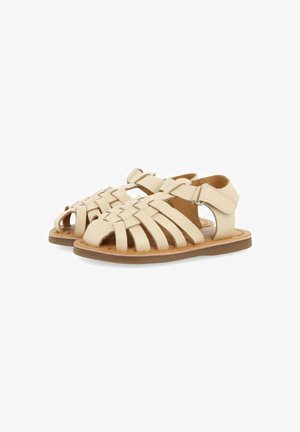Sandalias de cuero beige con un diseño trenzado, con la punta abierta, tira en el tobillo y suela plana. Acabado texturizado con interior acolchado para mayor comodidad.