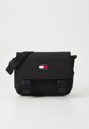 Sort messenger taske med et tekstureret stof, der har en klaplukning, justerbar rem og et logo på i røde, hvide og blå farver.