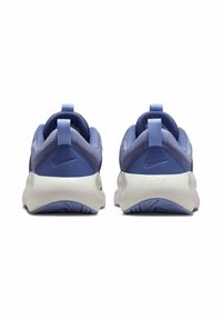 Zapatillas deportivas moradas con parte superior de tela lisa, tacón redondeado y suela de amortiguación blanca. Presentan una pestaña de tirón con bucle y detalle de logo.