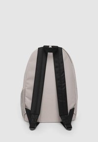 Zaino in tessuto grigio chiaro con spallacci neri, forma rettangolare, tasca laterale in rete e maniglia superiore per il trasporto. Design semplice e funzionale.