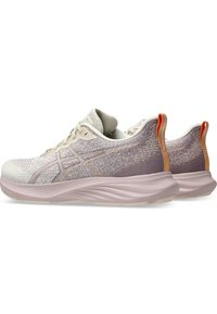 Baskets de sport avec une tige en toile légère de couleur beige clair et lavande, dotées d'une semelle épaisse et rembourrée ainsi qu'une languette en orange à l'arrière.