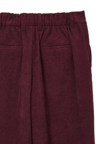Pantalons en velours côtelé bordeaux avec une surface texturée, taille élastique, plis et deux poches latérales.