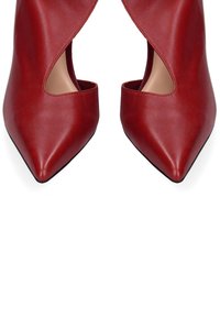 Décolleté in pelle rossa con punta affusolata e design con ritagli. Texture liscia e suola nera. Presenta una sottile lucentezza.