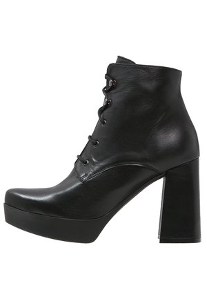 Stivaletti neri alla caviglia con finitura in pelle lucida, design con lacci, punta arrotondata, tacco alto a blocco e suola con plateau.