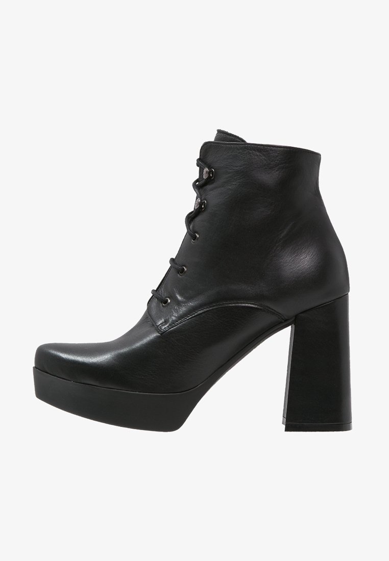 Bottines noires en cuir brillant, à lacets, bout arrondi, talon épais haut et semelle plateforme.