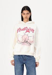 Cream hoodie with a graphic print featuring a sun and abstract mountain design in pink and black. Relaxed fit and ribbed cuffs.