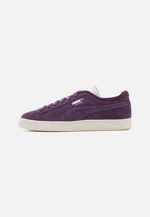 Niski buty sportowe Puma Suede w ciemnym fioletowym kolorze z białą podeszwą, sznurowaniem i logo na boku oraz języku.