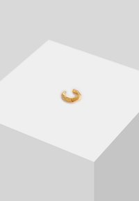 Guldfarvet ring med et tekstureret, geometrisk design, der har vinklede facetter og en åben båndform. Kompakt og lille i størrelse.