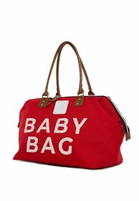 Rød canvas babytaske med store hvide bogstaver, der står "BABY BAG." Har brune pyntelederhåndtag og lynlåsdetaljer. Robust design.