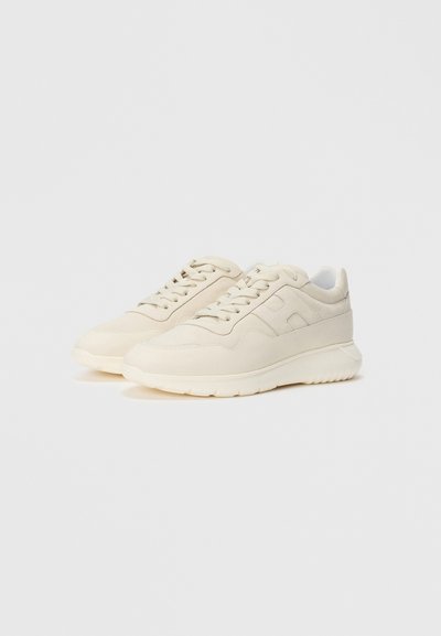 Pair of beige casual lace-up sneakers with thick soles and subtle side panel stitching against a light background.