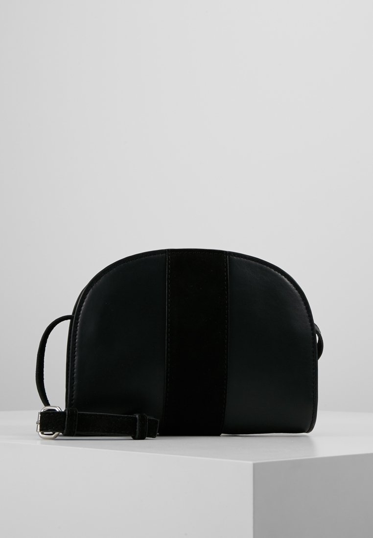 Borsa a mano in pelle e scamosciato nera con una forma arrotondata, caratterizzata da una striscia verticale in scamosciato, tracolla regolabile e superficie liscia.