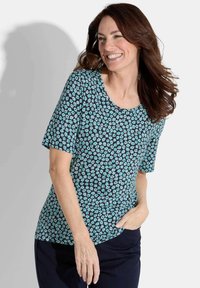 Kurzarmoberteil aus dunkelblauem Stoff, der mit kleinen aquafarbenen Blumenmustern verziert ist. Das Design hat einen runden Halsausschnitt und eine lockere Passform.