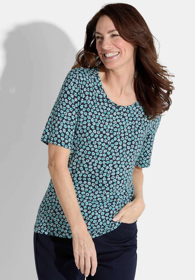 Kurzarmoberteil aus dunkelblauem Stoff, der mit kleinen aquafarbenen Blumenmustern verziert ist. Das Design hat einen runden Halsausschnitt und eine lockere Passform.