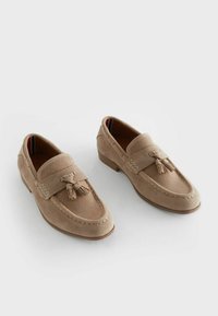 Mocassins beiges en cuir suédé et mesh, avec des accents de gland et des coutures contrastées, dotés d'un petit talon carré pour plus de stabilité.