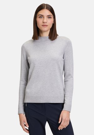 Light gray sweater with a high neckline, long sleeves, ribbed hem, and soft texture, paired with dark navy pants.