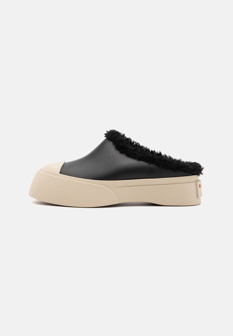 Chaussures noires en synthétique à enfiler avec une bordure noire en fourrure et une semelle épaisse beige. Design à bout rond et logo discret à l'arrière.