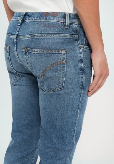Jeans in denim azzurro chiaro con una vestibilità dritta, dotati di due tasche posteriori, cuciture arancioni e una patch con il marchio sulla vita.