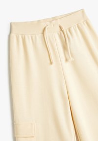 Lichtgele sweatpants hebben een ribbelband met trekkoord, zijzakken, een zachte textuur en een relaxed fit-design.
