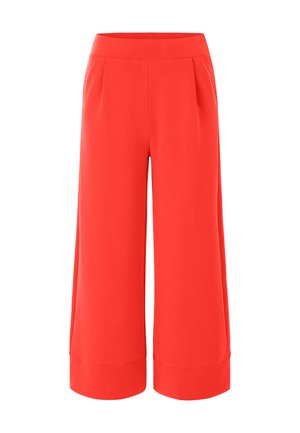 Culottes rouges à large jambe avec une texture lisse, dotées d'une taille haute et de détails de plis, conçues pour le confort et la liberté de mouvement.