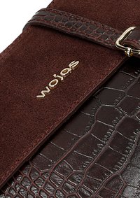 Borsa in pelle marrone scuro con una superficie liscia effetto cocodrillo e ricchi accenti in suede. Le finiture in oro includono una chiusura e il logo del brand.