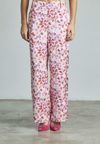 Wijdvallende broek van lichtgewicht stof, met een roze en paarse bladmuster op een witte achtergrond. Gladde textuur en hoge taille.