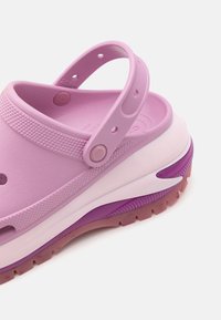 Pink rubber clog with a back strap, textured upper, ventilation holes, layered sole in white and pink, pink and purple gradient accents.
