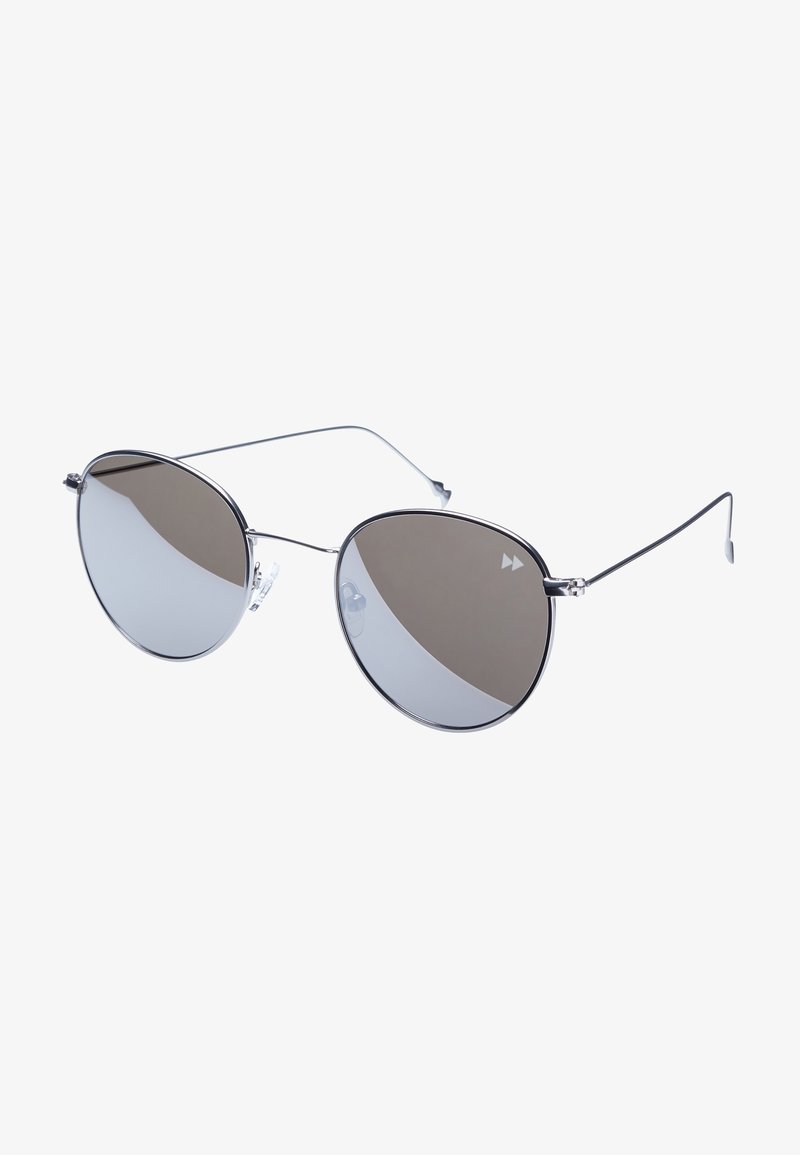 Gafas de sol de metal con montura ovalada, que presentan lentes oscuros y brazos delgados de color plata. Almohadillas nasales transparentes para mayor comodidad.
