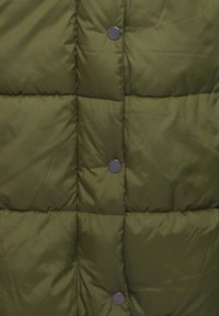 Maslinasto zeleni puffer jakna sa kvadratnim detaljima, s crnim kopčama na prednjem dijelu. Glatka, sjajna tekstura tkanine.