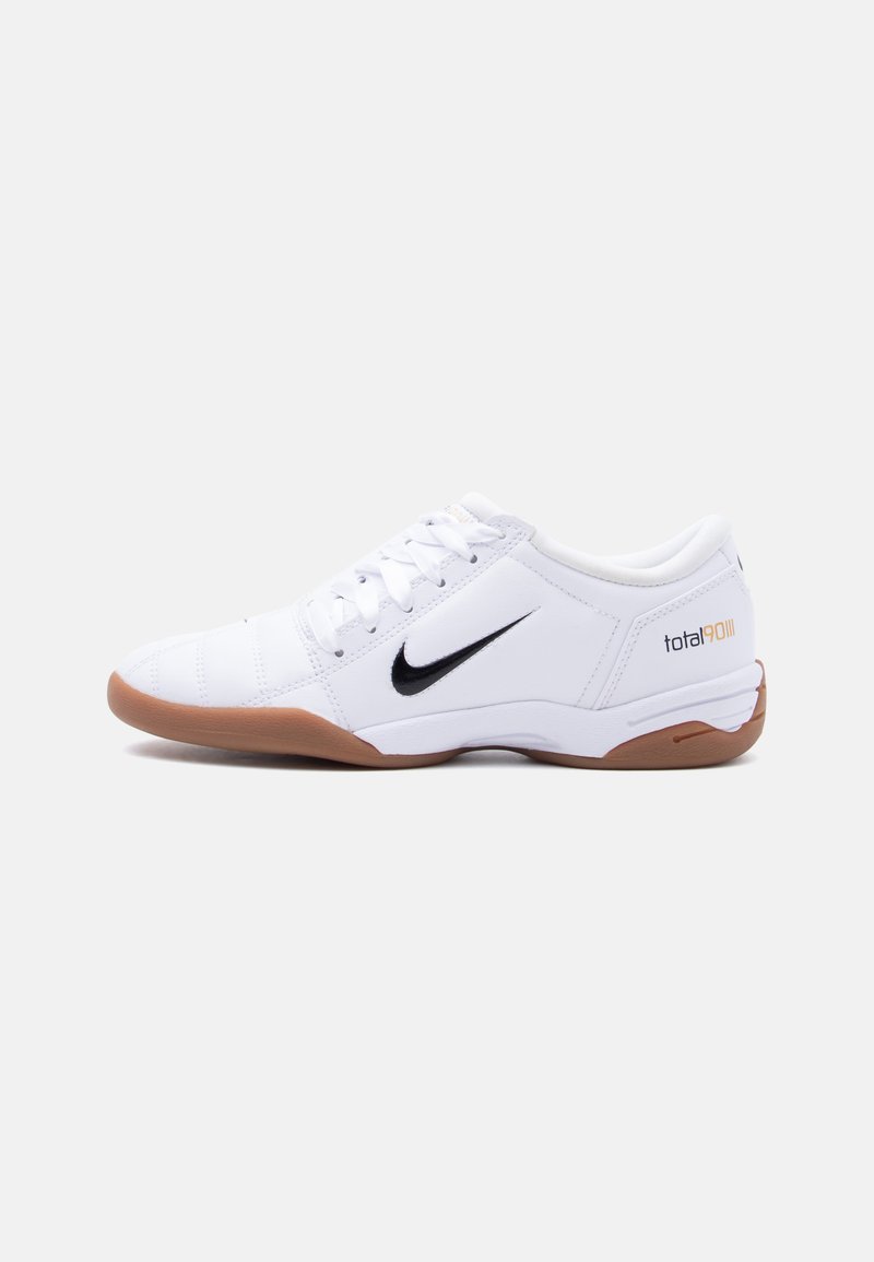 Άσπρο παπούτσι ποδοσφαίρου Nike Total 90 III για εσωτερικούς χώρους με μαύρο λογότυπο Swoosh και καφέ σόλα, εμφανιζόμενο από το πλάι σε απλό φόντο.
