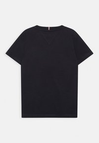 Černé tričko s krátkým rukávem vyrobené z měkké bavlny. Má kulatý výstřih a malou centrální etiketu na zadní straně. Hladká textura, jednoduchý design.