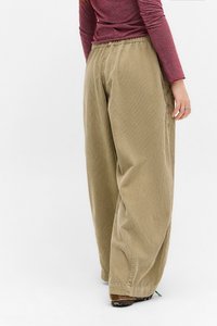Pantaloni a gamba larga in corduroy marrone chiaro con vita elastica. Presentano una sottile rigatura verticale e una vestibilità comoda che scivola delicatamente.