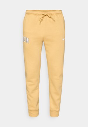 Dzeltenas šortus ar aukliņu, elastīgiem manžetiem, ar tekstu "BOSTON" uz kreisā augšstilba un nelielu baltu Nike logo uz labā augšstilba.