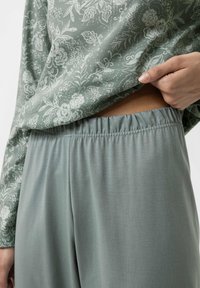 Light green floral-patterned long-sleeve top with elastic waistband pants in a matching hue, showcasing smooth texture and relaxed fit.
