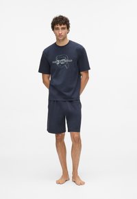 Tamno plavi pamučni kratkotrajni majica s kratkim rukavima s grafičkim logotipom i odgovarajućim šortsevima, jednostavnog kroja, glatke teksture i opuštenog kroja.